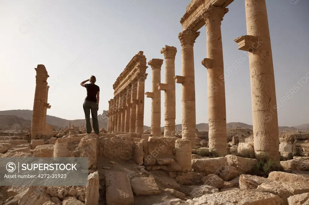 Syria, Palmyra. A tourist  stands amongst the ancient ruins of Queen Zenobia's city at Palmyra.(MR)