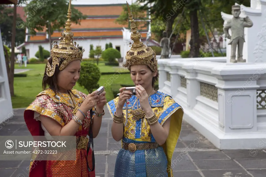 Girls in Thai dancing costumes in front of Wat Arun temple in Bangkok Thailand