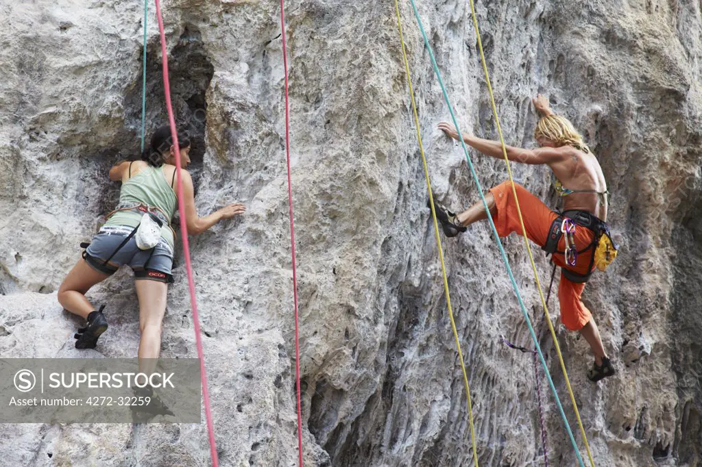 Women rock climbing at Muay Thai Wall on Hat Rai Leh East Beach, Railay, Krabi Province, Thailand