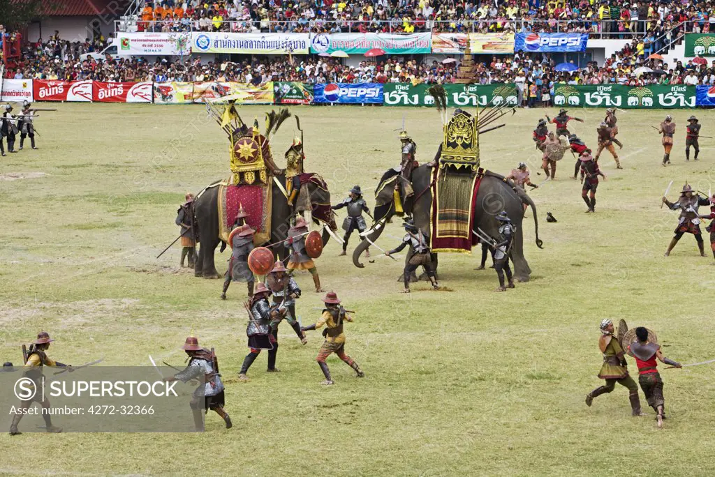Thailand, Surin, Surin.  Soldiers battle in an ancient war re-enactment during the Elephant Roundup festival.  The event held in November sees hundreds of elephants involved in a celebration of the region's proud elephant history and traditions.