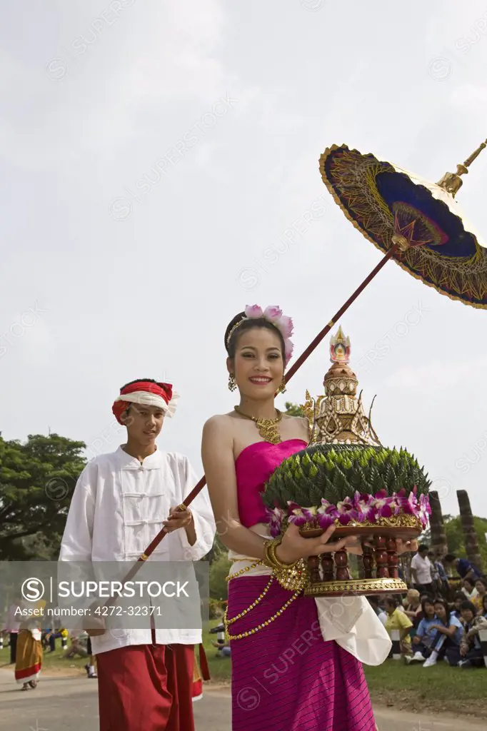 Thailand, Sukhothai, Sukhothai. Woman carrying a ceremonial krathong during the festival of Loi Krathong at the Sukhothai Historical Park. The festival held in November features cultural performances, parades and the floating of lotus shaped boats (krathong).