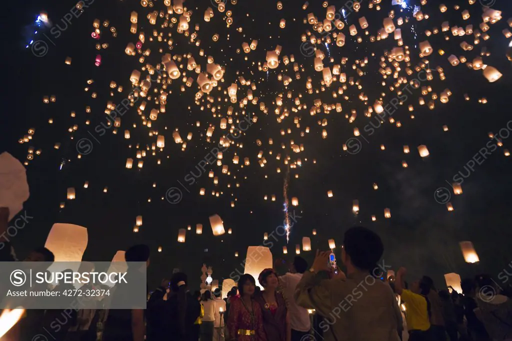 Thailand, Chiang Mai, San Sai.  Revellers launch khom loi (sky lanterns) into the night sky during the Yi Peng festival.  The ceremony is a Lanna (northern Thailand) tradition and coincides with Loy Krathong festivities.  The khom loi are released in the belief that grief and misfortune will float await them, bringing good luck.