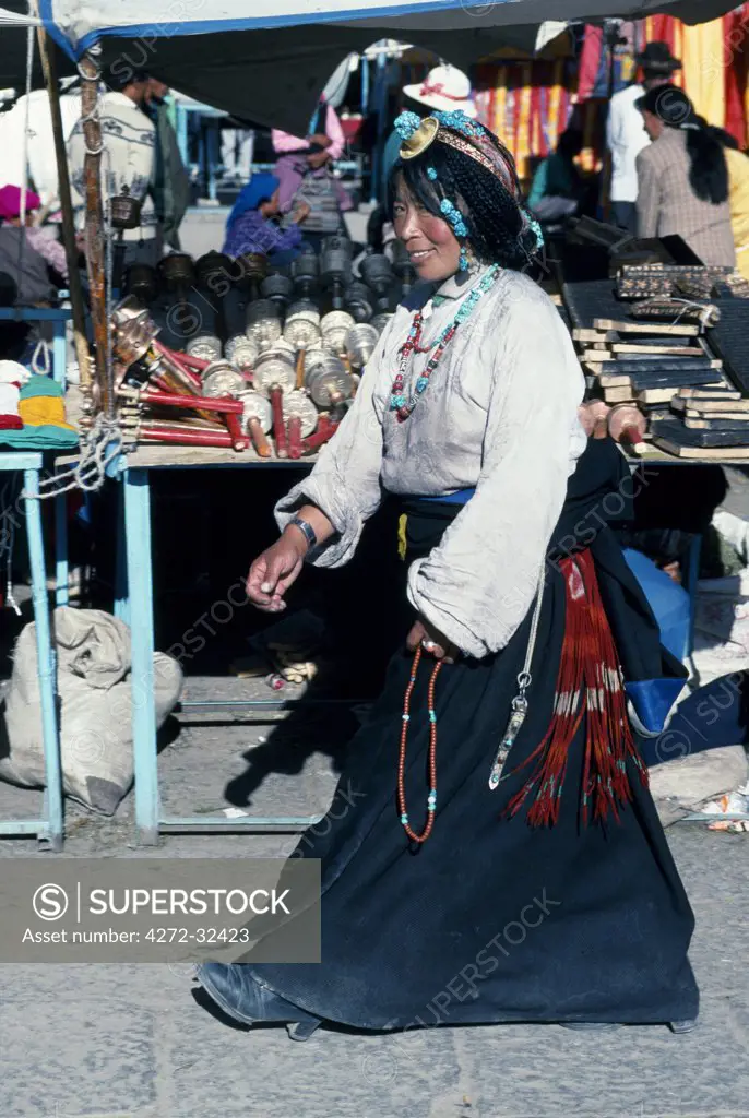 A young Tibetan woman strolls the Barkhor, the holiest of Lhasa's circumambulatory devotional routes