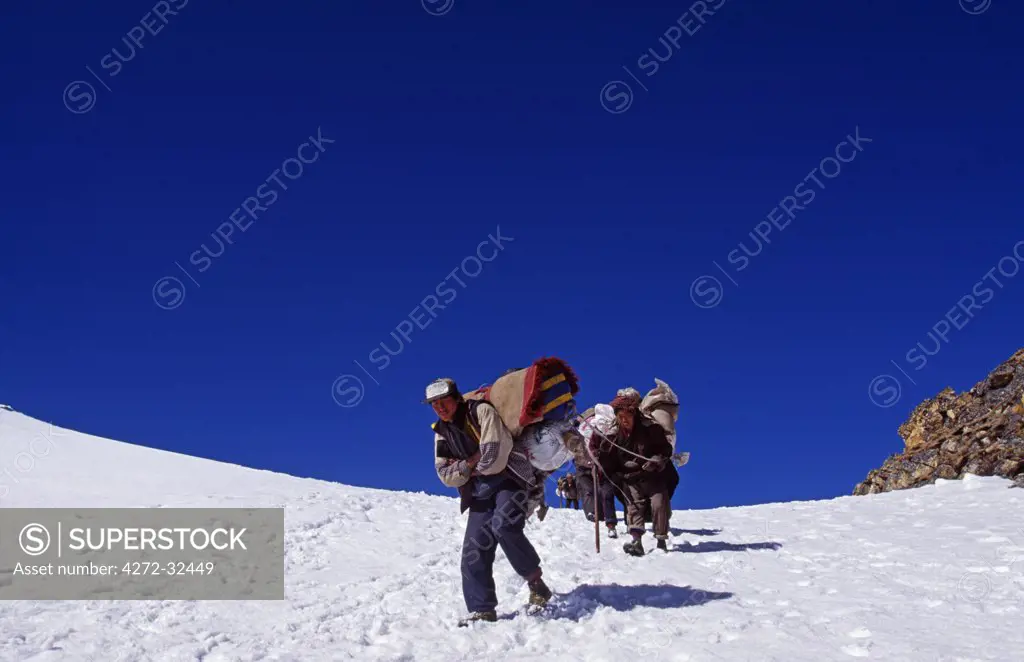 Tibet, Chomolungma, Kangshung Valley. Porters crossing the Sho La Pass into the Kangshung Valley on the way to the East side of Mount Everest. The Kangshung Valley was used by mountaineering expeditions seeking to climb Mount Everest in 1920's because Nepal was closed to foreigners.