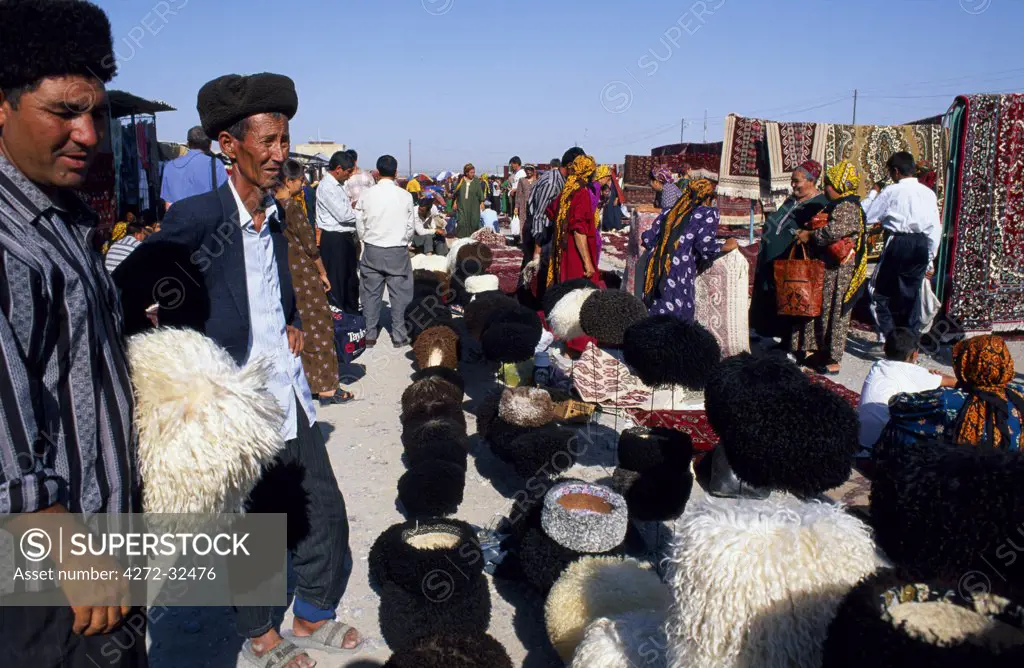 Turkoman men look at hats for sale at a market stall at Tolkuchka Bazaar.