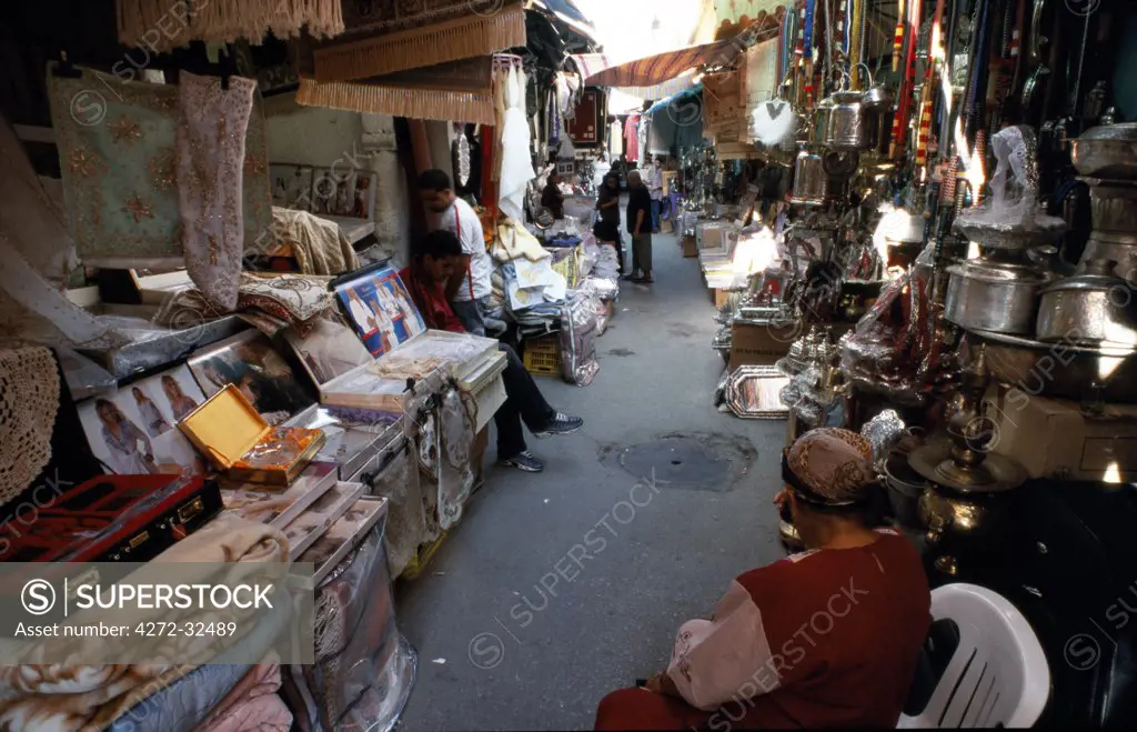 Market stalls sell blankets, rugs, and bric a brac in the medina