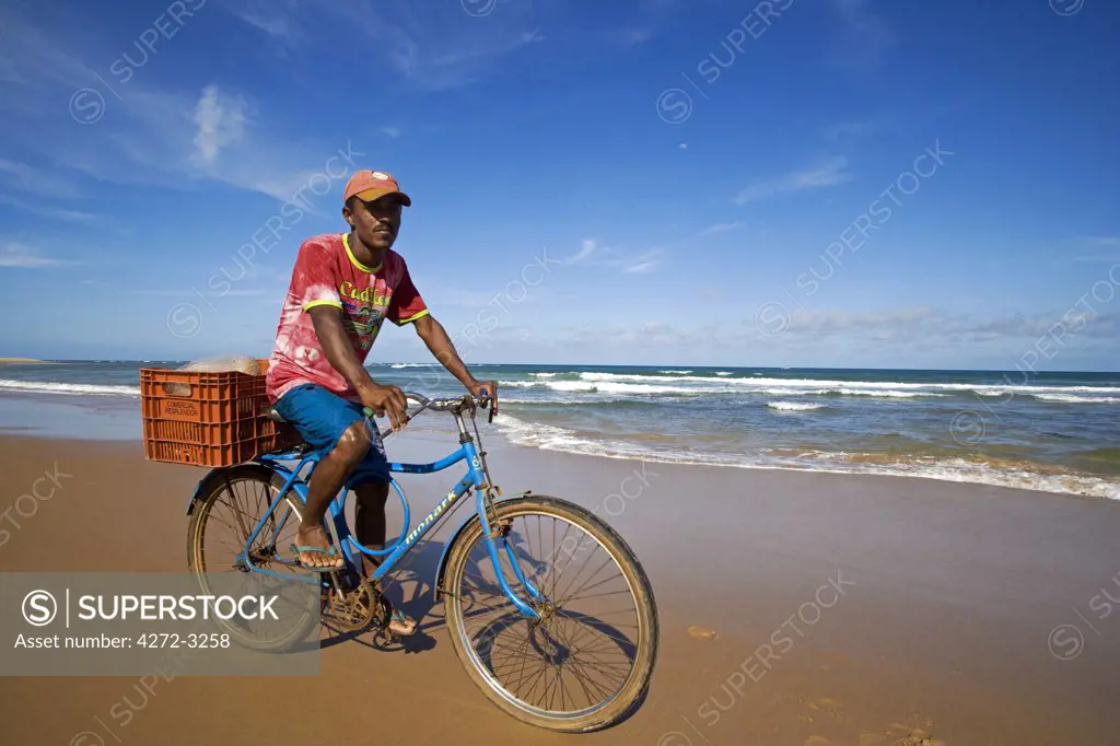 Brazil, Bahia, Barra Grande. Local fisherman rides the beach in search of signs of fish in the surf line.