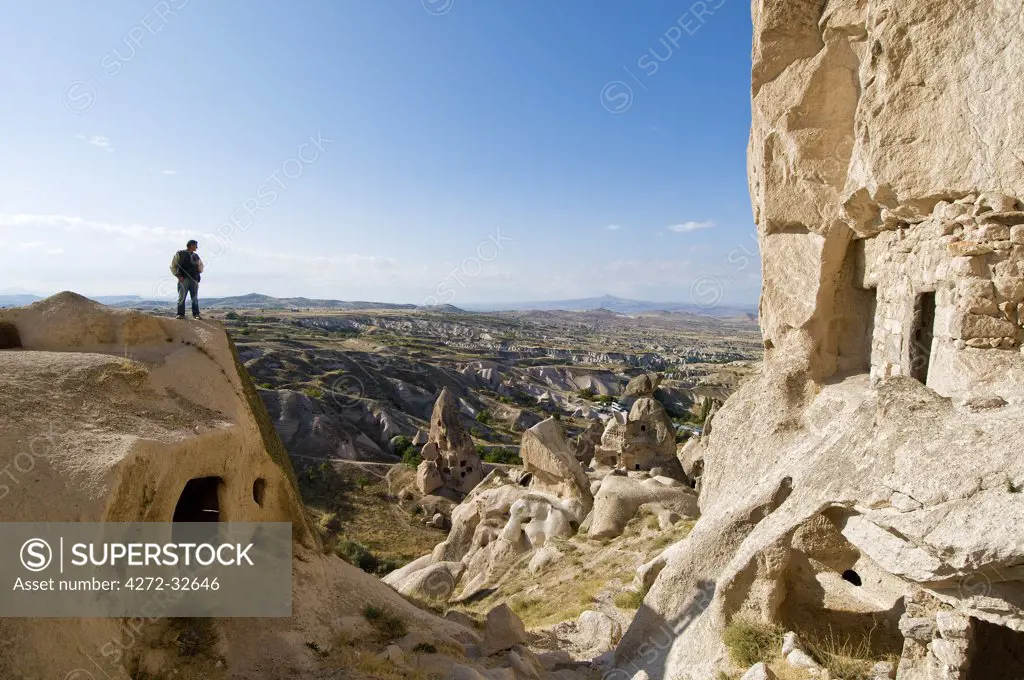 Rocky dwellings at Uchisar, with a solitary man. Cappadocia, Turkey, Asia