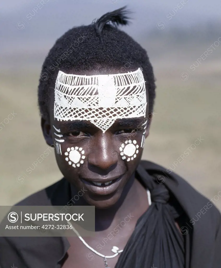 Black clothing and the intricate white patterns on the face of this Maasai youth of the Kisongo section signify his recent circumcision.