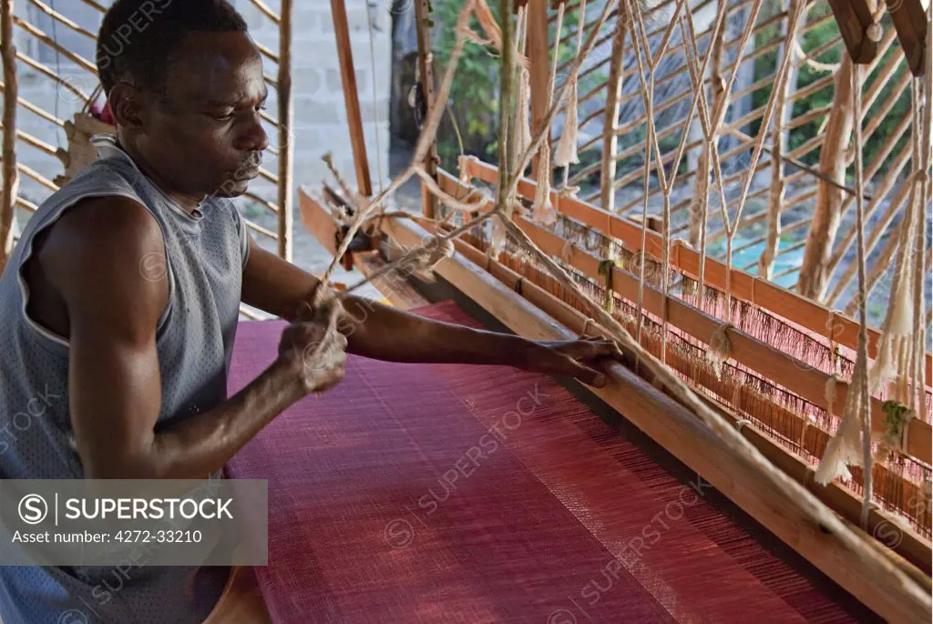 Tanzania, Zanzibar. A skilled weaver at his wooden loom.