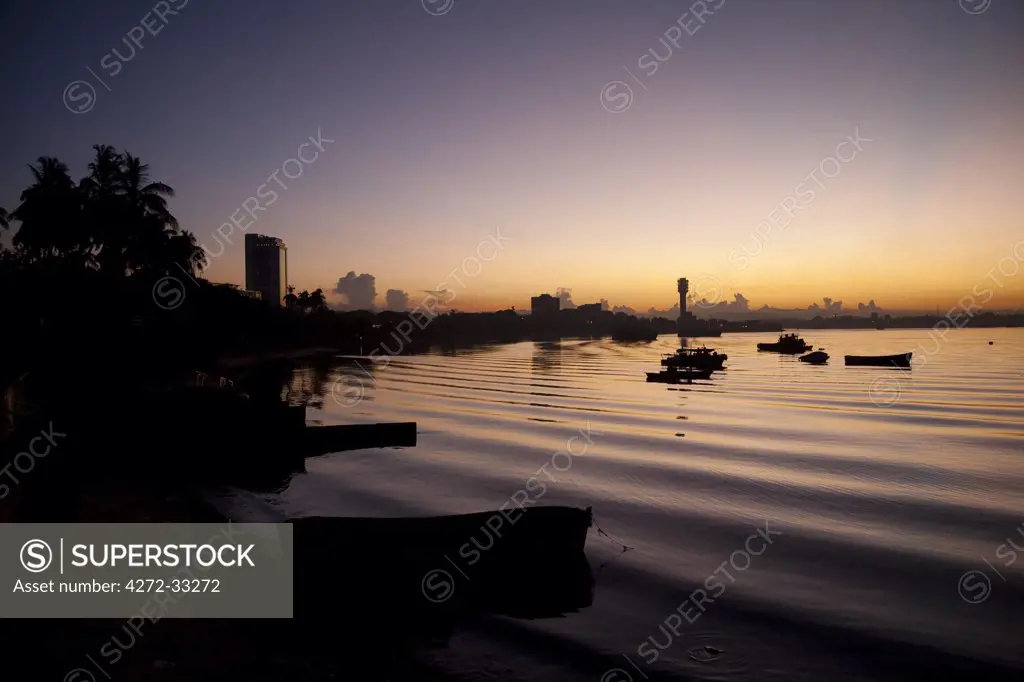 Tanzania, Dar es Salaam. Boats bob on the peaceful morning tide at sunrise.