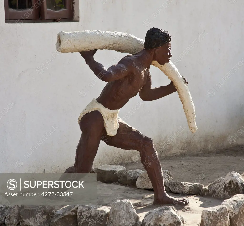 The modern sculpture of a slave carrying ivory outside the 19th century Caravan-serai building at Bagamoyo.  Bagamoyo was a major centre for exporting slaves in the 19th century.