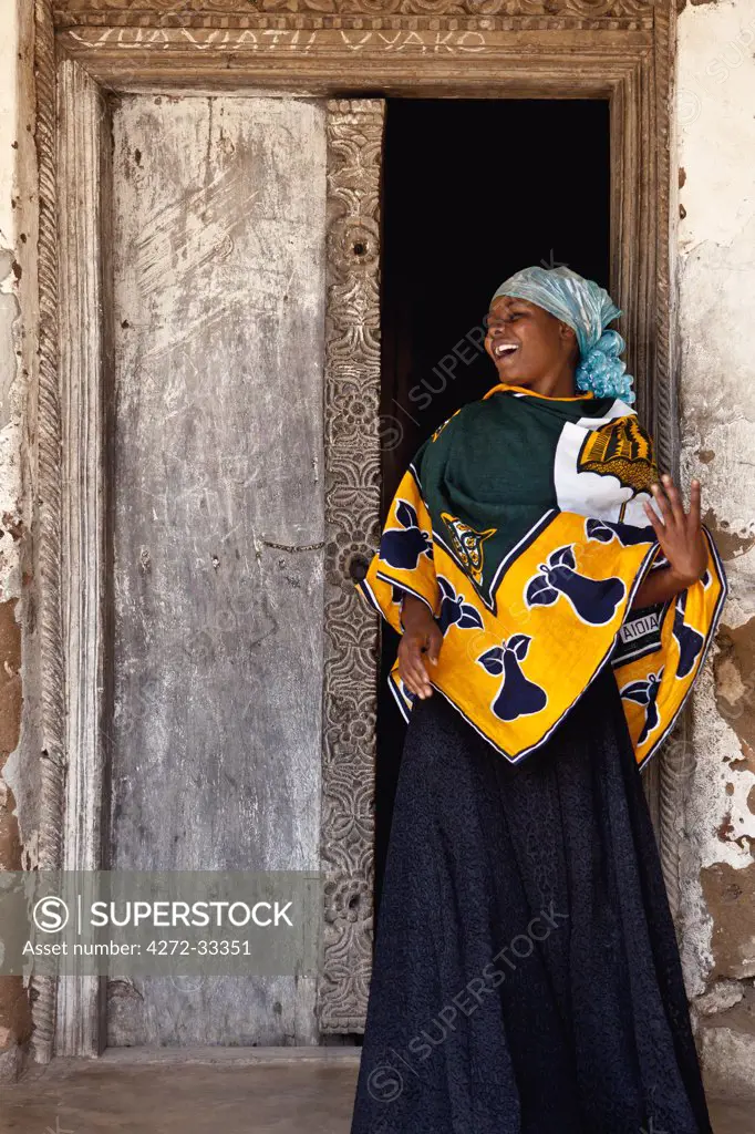 A jovial woman at the traditional carved wooden doorway to her house at Kaole, north of Dar-es-Salaam.
