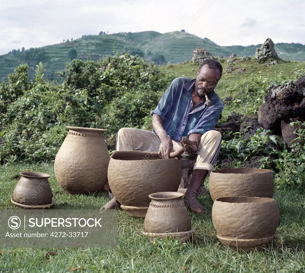 A potter fashions cooking pots by the coil method, shaping them by eye alone. Surprisingly, craft skills such as pottery and basket-making are the sole preserve of men in Southwest Uganda.