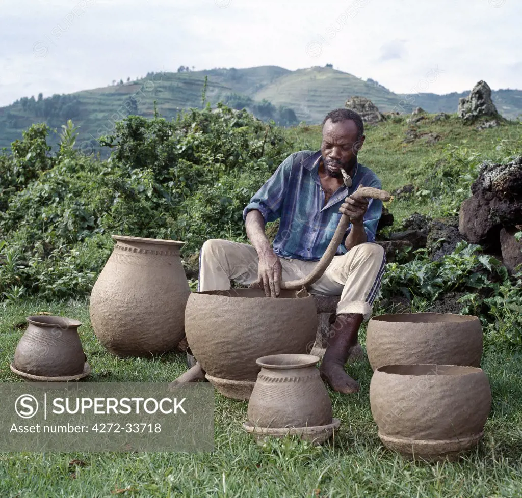 A potter fashions cooking pots by the coil method, shaping them by eye alone. Surprisingly, craft skills such as pottery and basket-making are the sole preserve of men in Southwest Uganda.