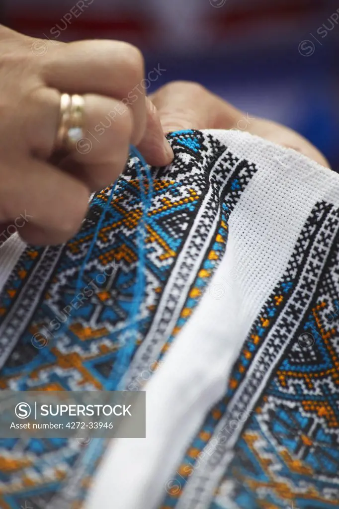Woman sewing traditional pattern onto cloth at Craft Market, Lviv, Ukraine