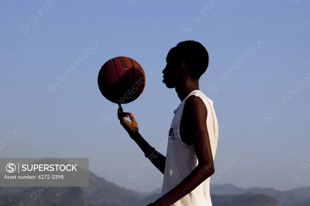 Burundi. A young man plays basketball in central Bujumbura.