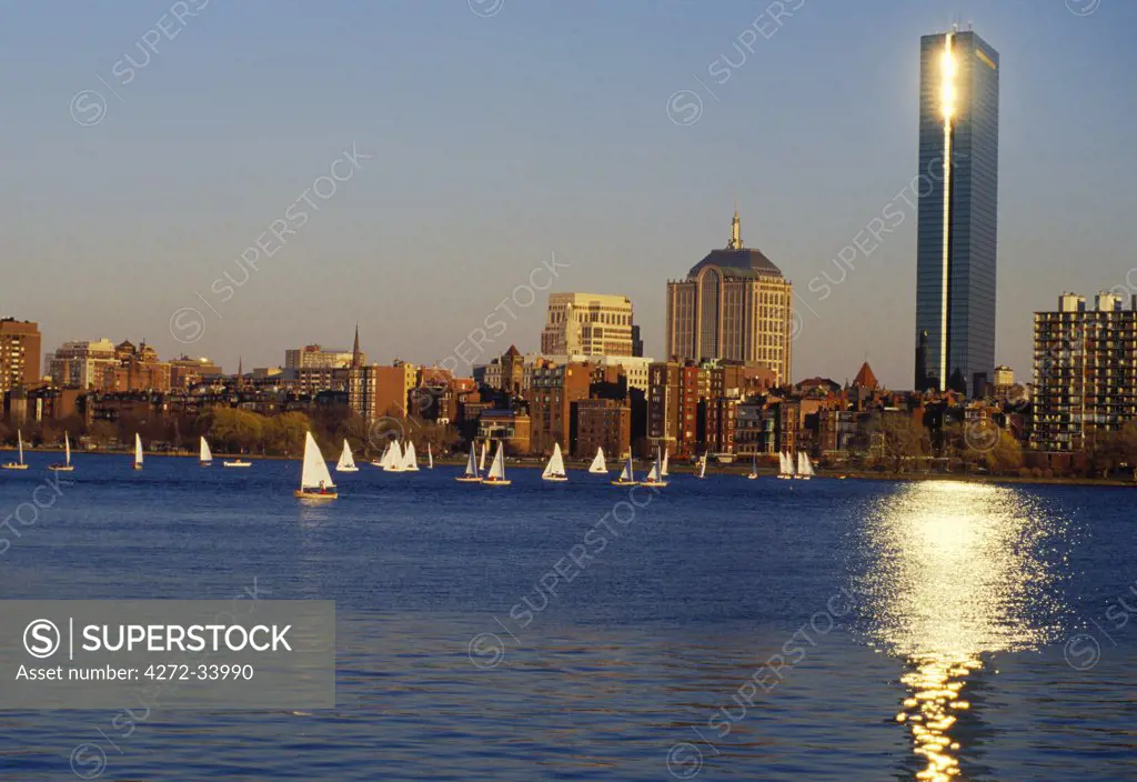 . Boston skyline at sunset with yachts on the Charles River.