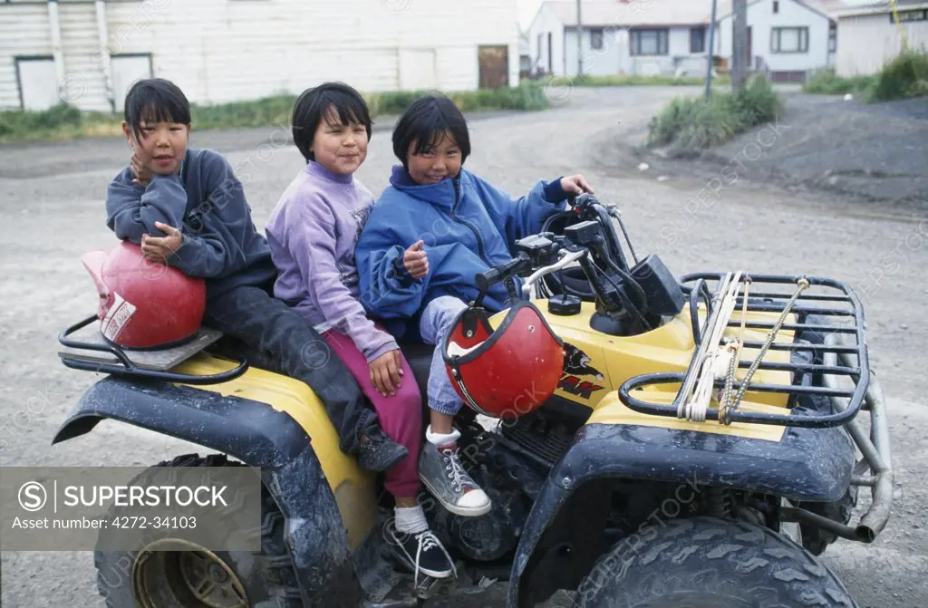 The Katchatag sisters aged seven eight and nine on a four wheeler,Alaska, USA