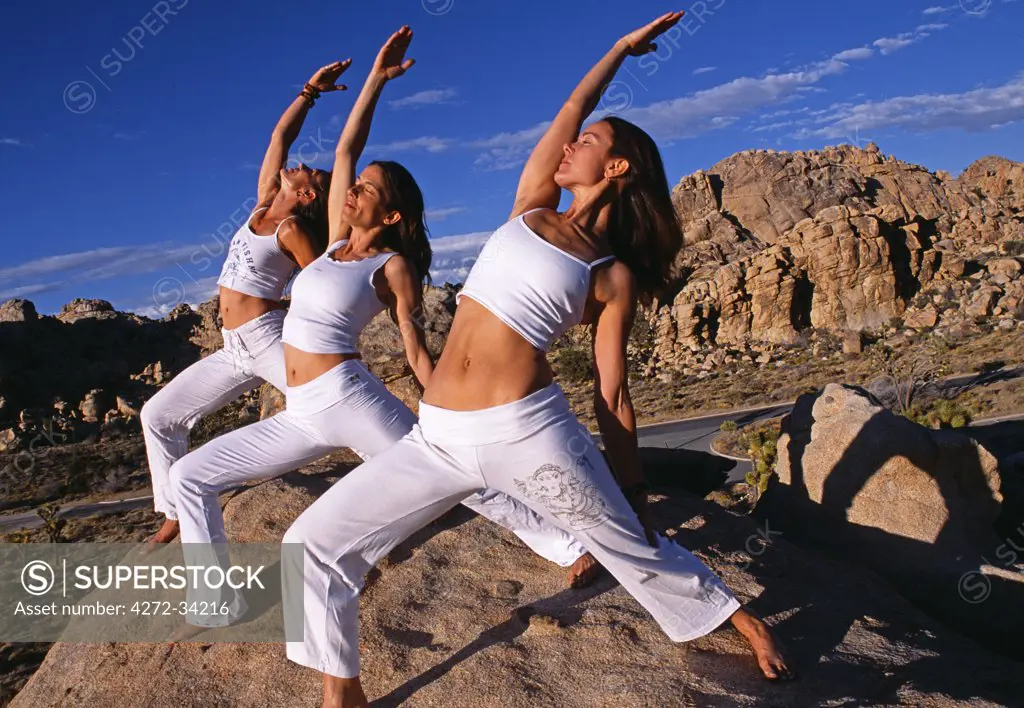 Yoga in the Joshua Tree National Park, all three women are holding a variation of 'Virabhadrasana 1' Warrior 1 also known as Ecstatic Warrior as in this pose you can experience a natural feeling of bliss.