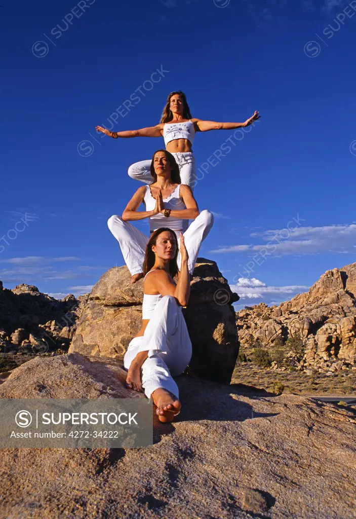 Yoga in the Joshua Tree National Park, the girl at the top is in a variation of 'Baddha Konasana' bound ankle pose, the middle girl in preparation fo the 'Vrksasana' tree pose. The girl in the front is holding a variation of 'Marichyasana' seated twisting pose..