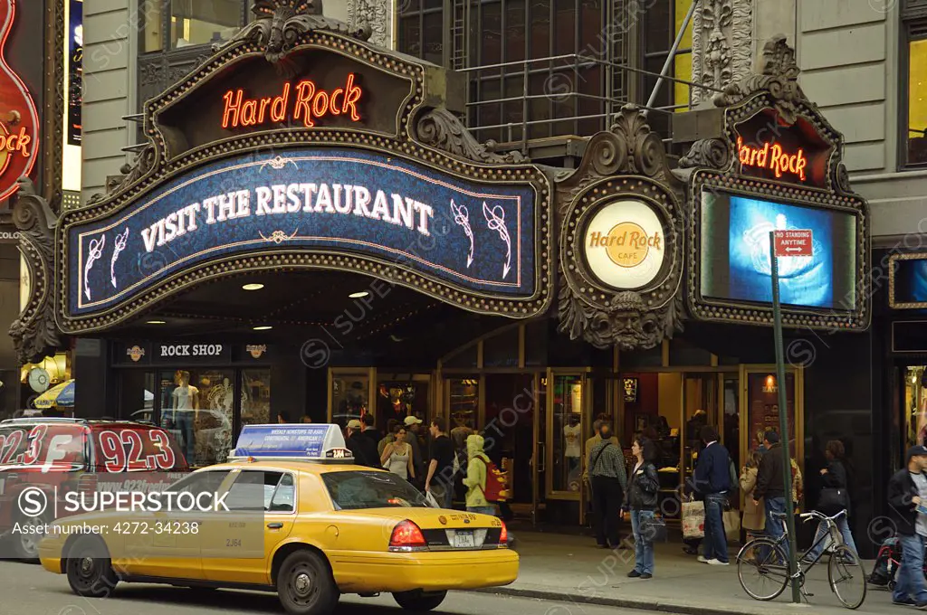 A New York City taxi passes in front of the Hard Rock Cafe in Time Square