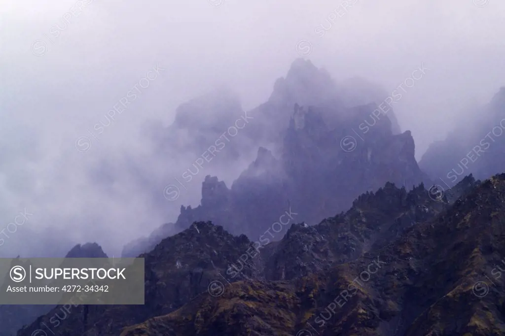 USA, Alaska. Fog shrouds mountains in the Alaska Range. Part of the Talkeetna Mountains, they are locally called the Craggies. The East Fork of the Chulitna River lies at the base of the mountains, located about 22 miles south of Cantwell, Alaska.