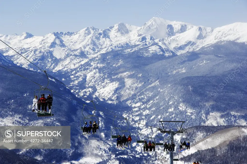 USA, Colorado, Vail Ski Resort. Skiers being carried on a chair lift in Vail back bowls