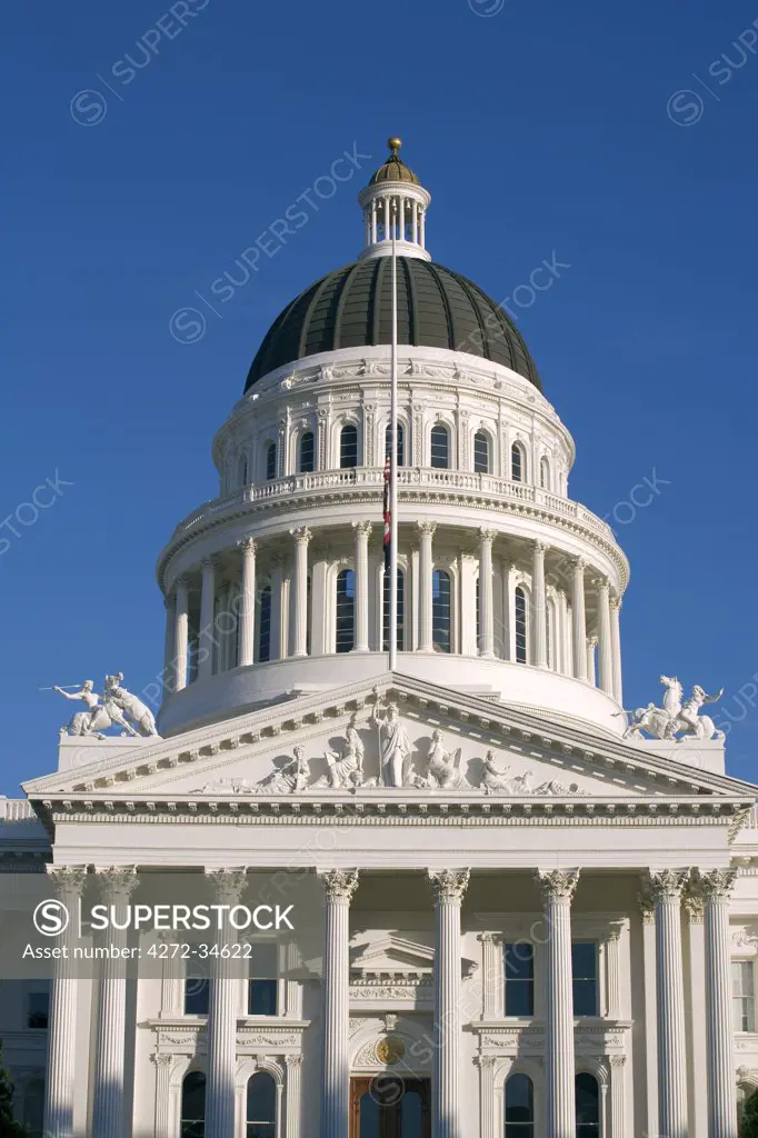 United States, California; Sacramento. West facade of the State Capitol building showing the dome and portico with its triangular pediment and eight fluted Corinthian columns.