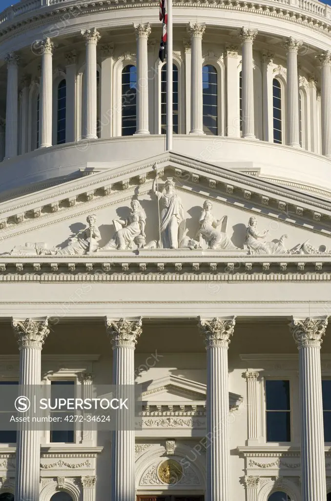 United States, California; Sacramento. West facade of the State Capitol building showing a close-up of the triangular pediment bearing the statue of Minerva bordered on her left by Justice and Mining, and to her right by Education and Industry.and industry.
