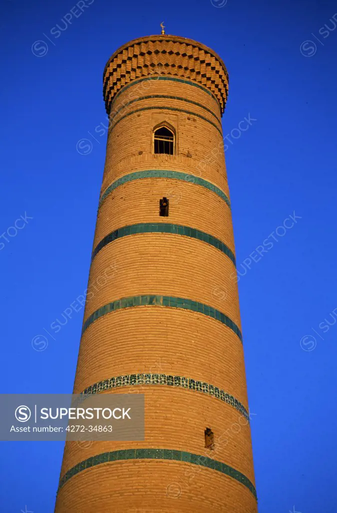 The tall minaret of a mosque rises above the old city of Khiva.