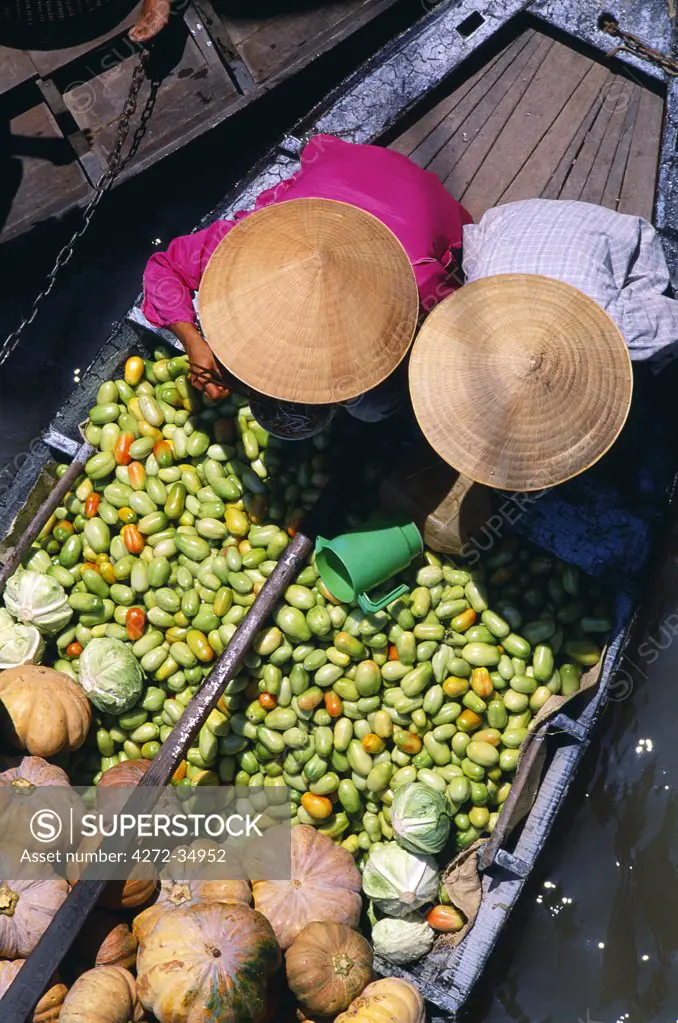 Overview of two women sorting vegetables on a boat at the floating market on the Mekong River, near the town of Cantho.