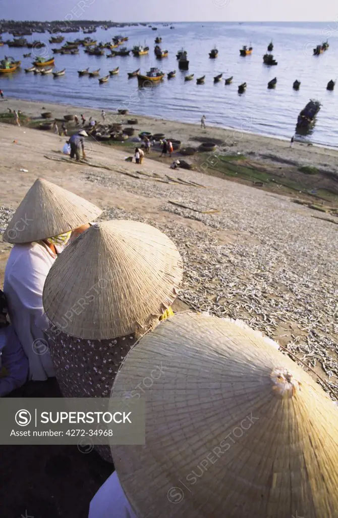 Women sitting next to drying fish, Mui Ne, Vietnam
