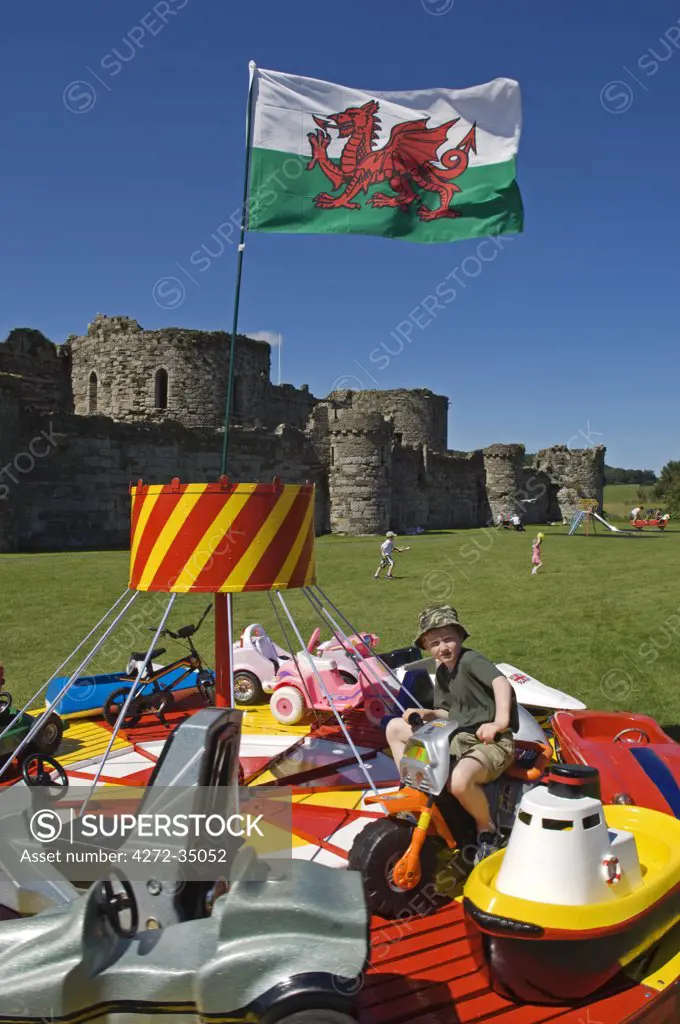 Wales, Anglesey, Beaumaris. A boy enjoys a fairground ride in the grounds of Beaumaris Castle. (MR)