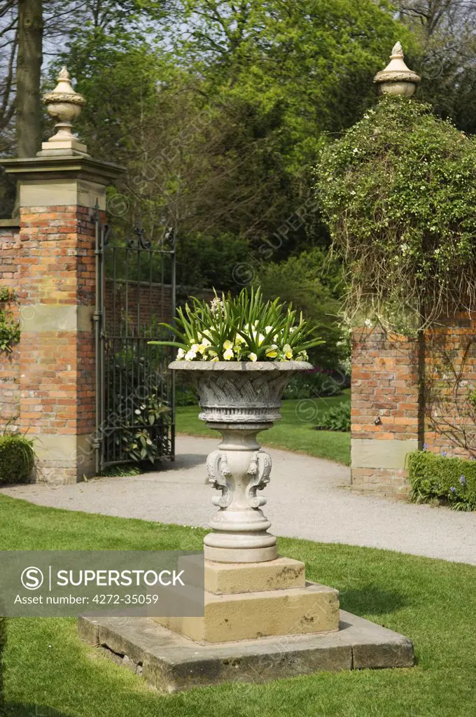 Wales, Wrexham. Erddig Hall - a formal urn planted with flowers, in the restored 18th Century garden at Erddig.