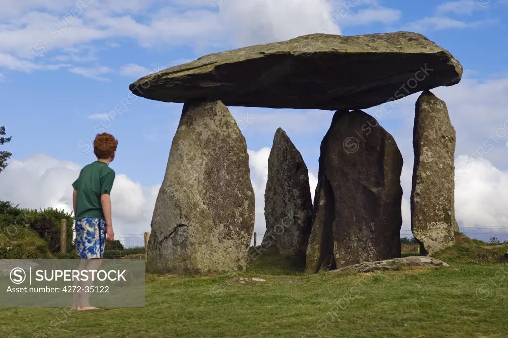 UK, Wales, Pembrokeshire. A young boy visits the site of the ancient neolithic dolmen at Pentre Ifan, Wales's most famous megalith, the remains of a vast Celtic burial mound, (MR).
