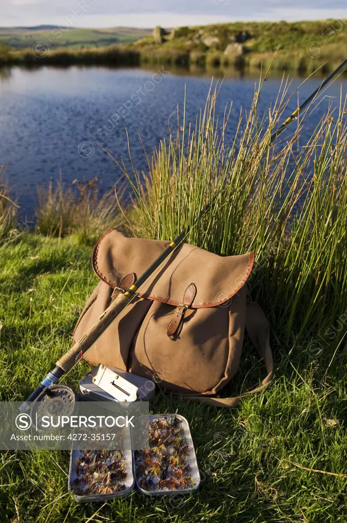 UK, Wales, Conwy. A trout rod and fly fishing equipment beside a hill lake in North Wales