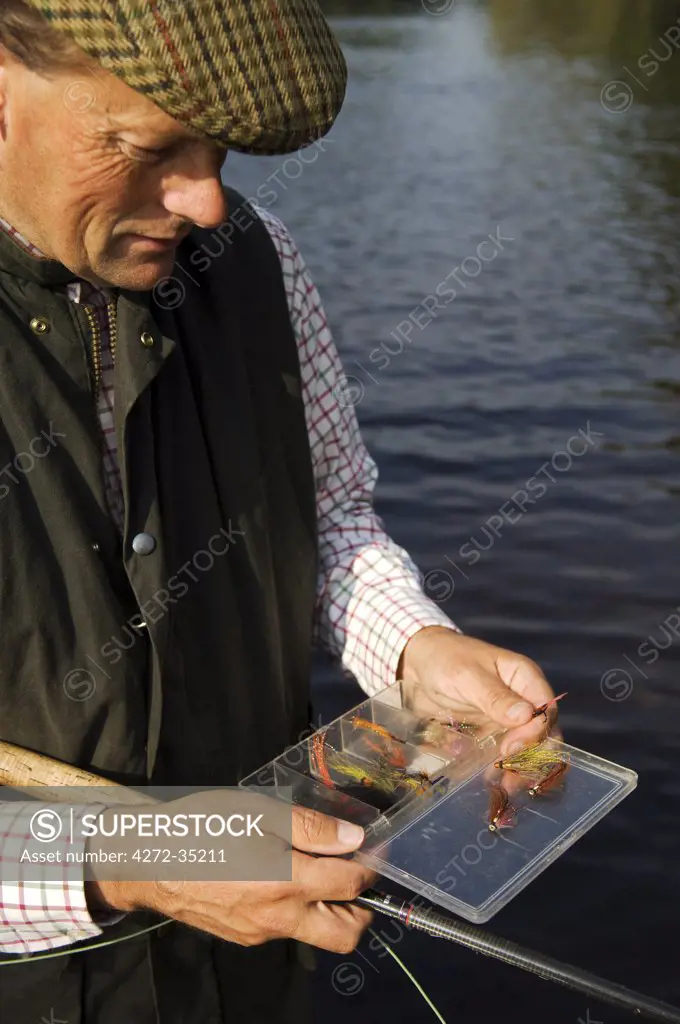 Wales Wrexham. A fisherman selects a fly while salmon fishing on the River Dee