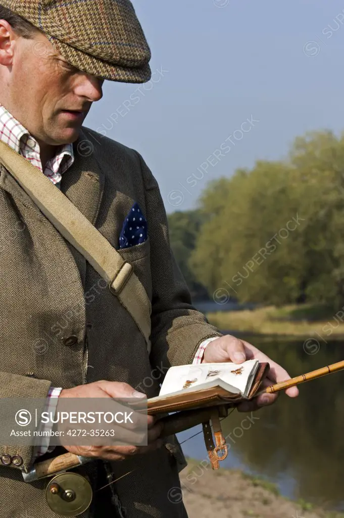 Wales; Wrexham. A trout fisherman selects his fly to fish on the River Dee. (MR)