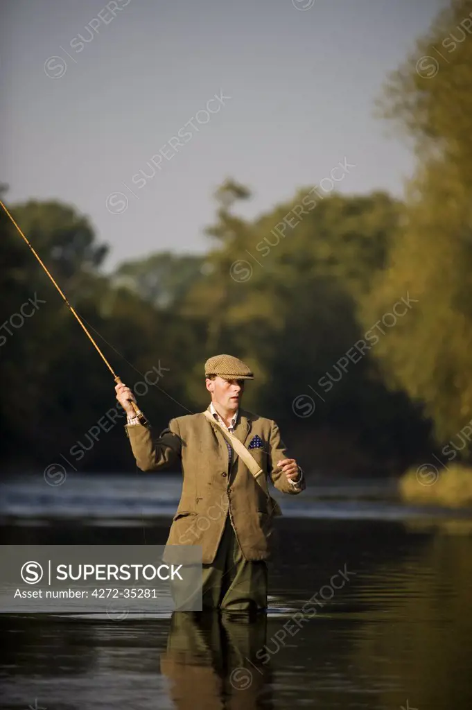 Wales; Wrexham. A trout fisherman casting to a fish on the River Dee (MR)
