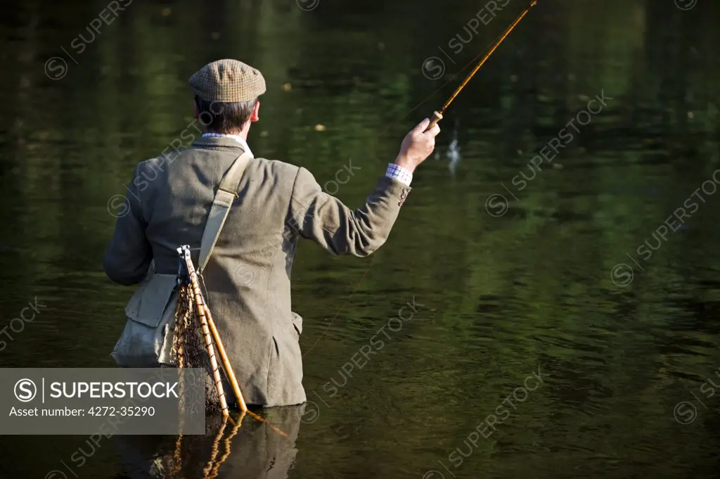 Wales; Wrexham. A trout fisherman casting to a fish on the River Dee (MR)