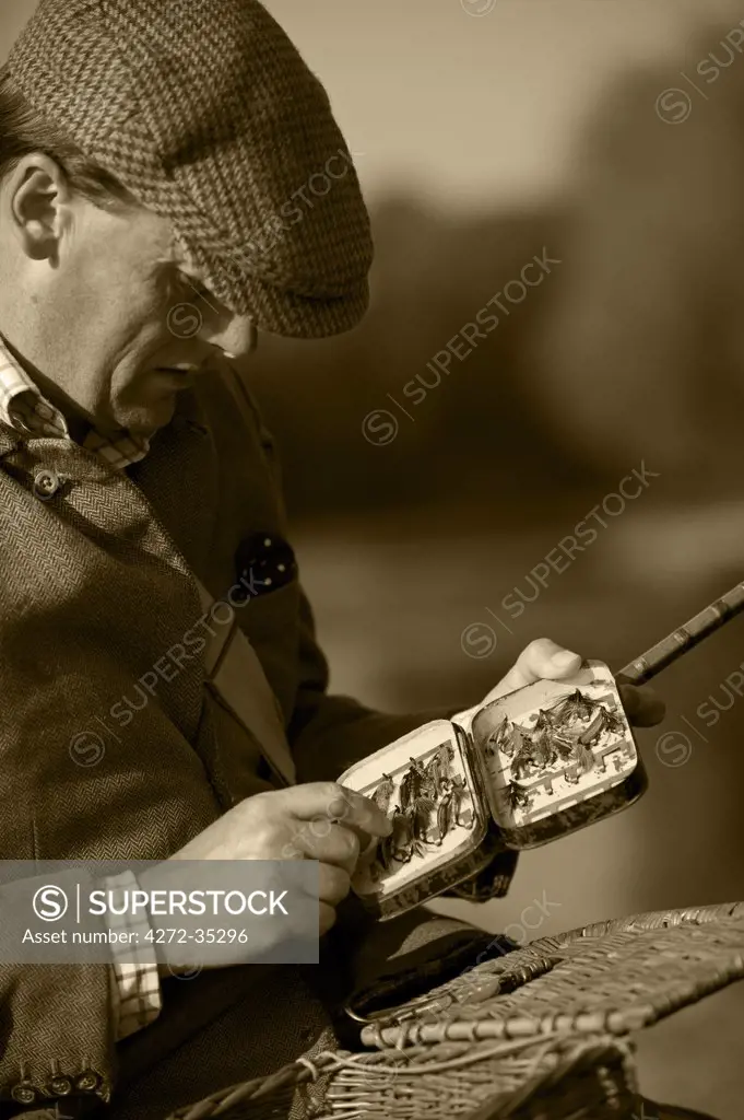 Wales, Wrexham. A fisherman selects a fly while salmon fishing on the River Dee