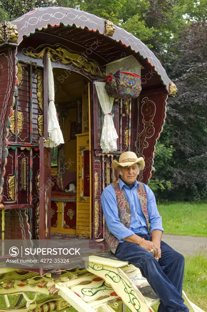 Wales, Wrexham. A Traveller sits on the front of his beautifully painted gypsy caravan.