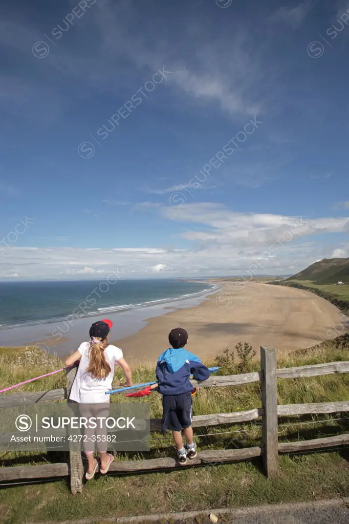 Wales; Gower Peninsula. A young boy and girl look out across Rhossili Bay. (MR)