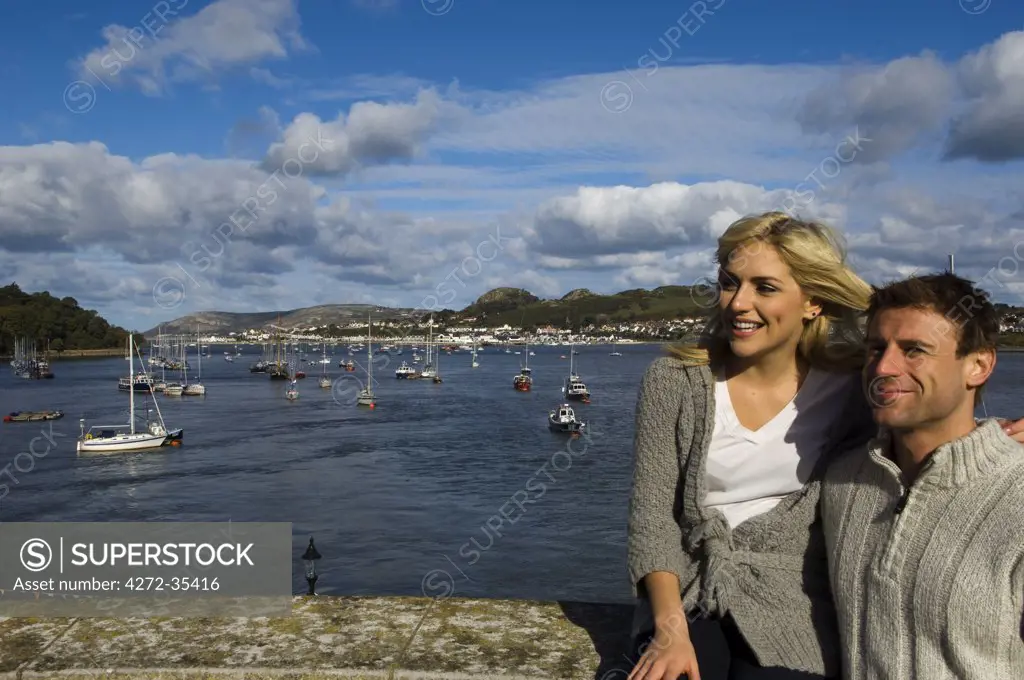 UK, North Wales; Conwy. Couple relax on the Conwy waterfront of the Conwy River.  (MR)