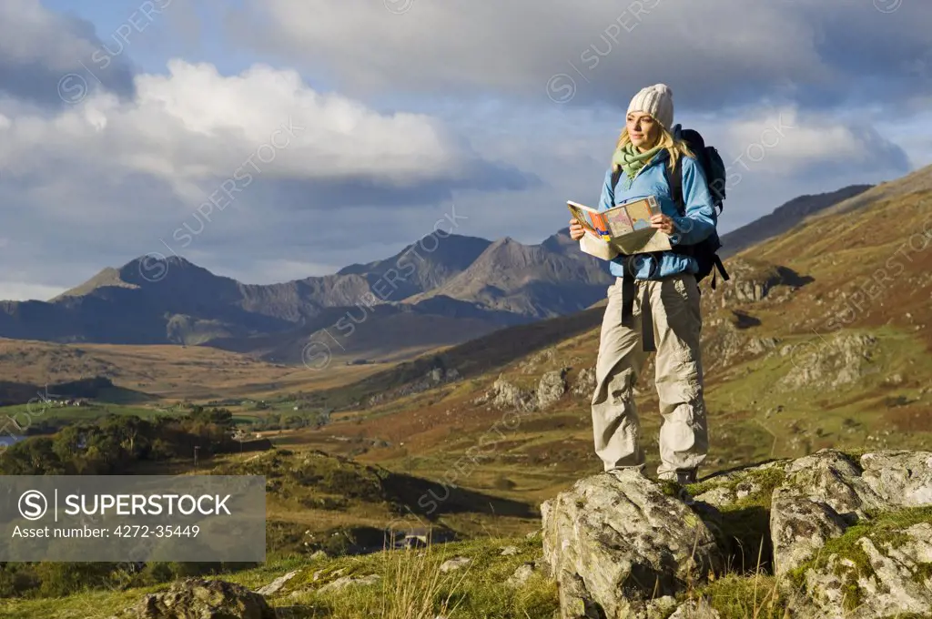 North Wales, Snowdonia.  A woman stop to look at the map whilst hiking in Snowdonia.  (MR)
