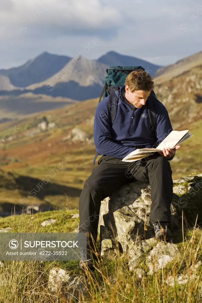 North Wales, Snowdonia.  A man stops to look at hisr map whilst hiking in Snowdonia.  (MR)