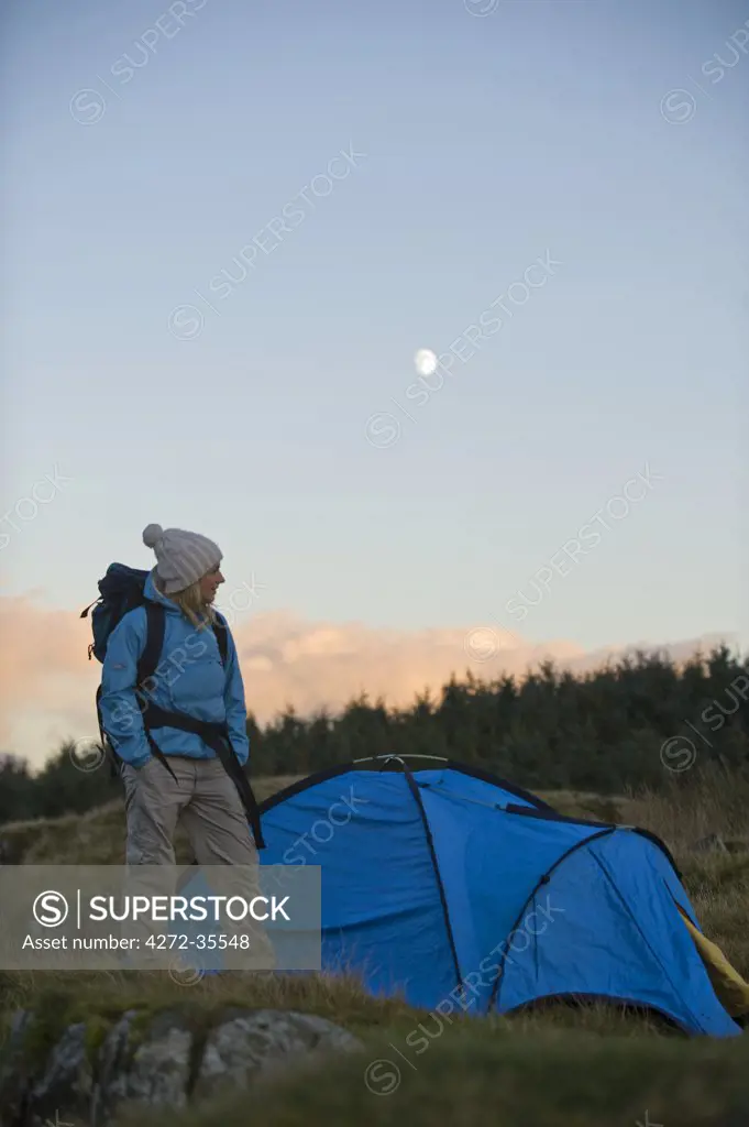 North Wales, Snowdonia, Gilar Farm.  Woman camping in the wild.