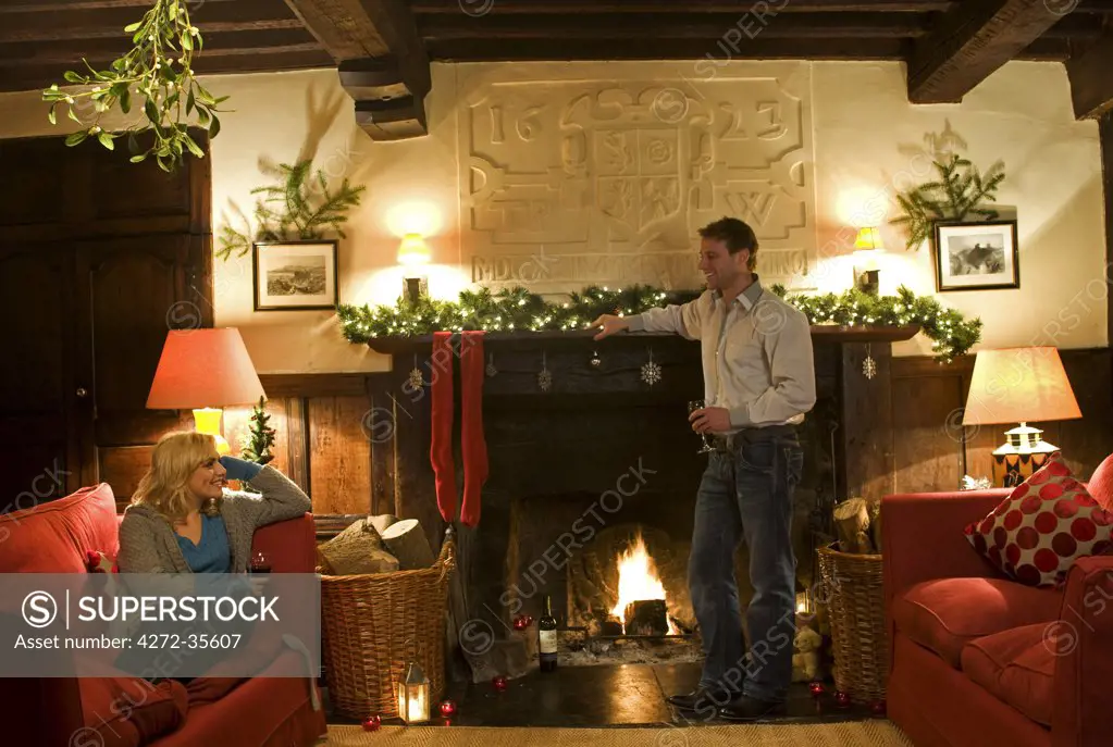 Gilar Farm, Snowdonia, North Wales.  A couple relax in the sitting room at Gilar at Christmas.