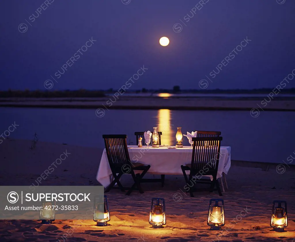 Zambia, Lower Zambesi National Park. Moonlit dinner on an island in the middle of the Zambezi River.